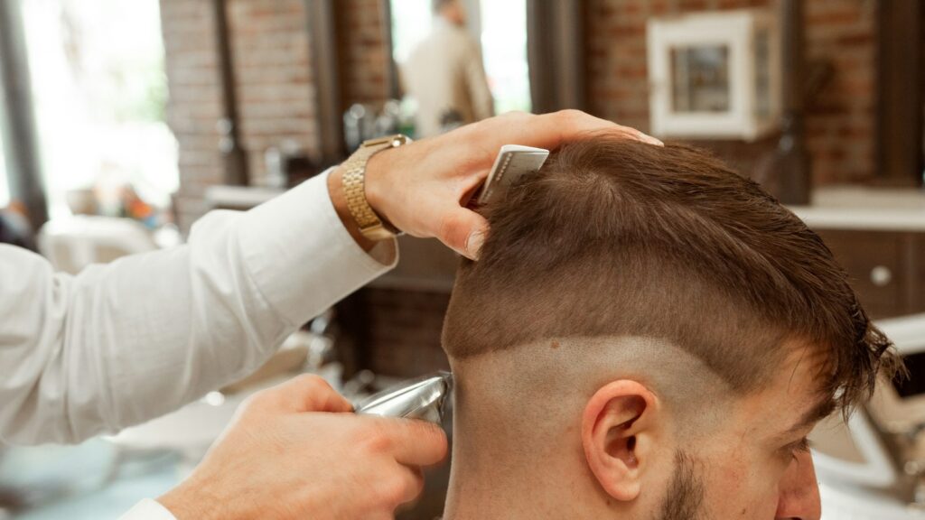 Fryzjer strzyże klienta w salonie